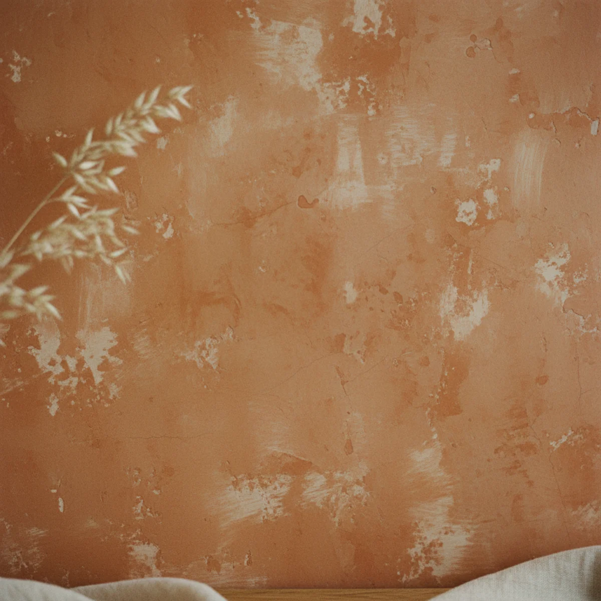 Terracotta color palette — close-up of terracotta color-washed wall showing visible variation, lighter areas over raised plaster texture, and deeper tones in recesses reading as authentic aged Mediterranean plaster — Home Decor Aura