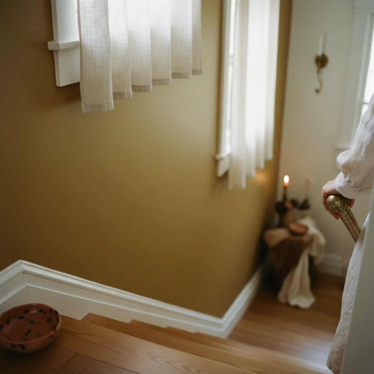 Warm paint colors — bedroom with single accent wall painted in Farrow & Ball India Yellow 66 ochre behind bed with cream walls on other three walls and warm wood floors — Home Decor Aura